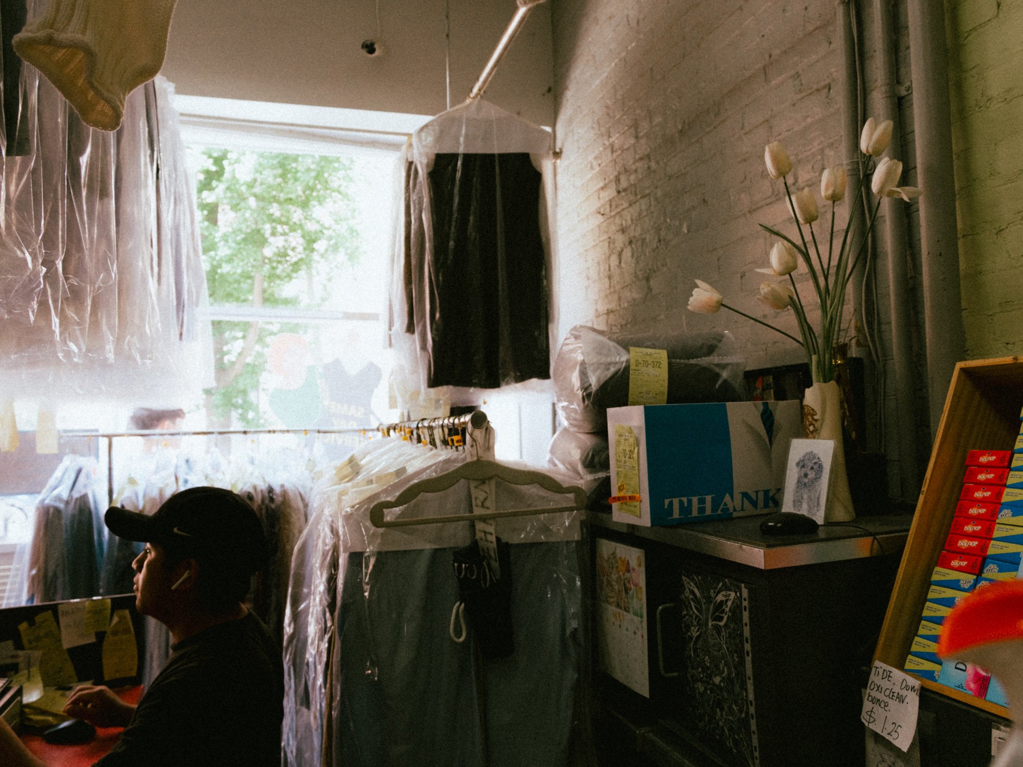 Dry cleaning counter with hanging garments at Brooklyn Heights Laundry