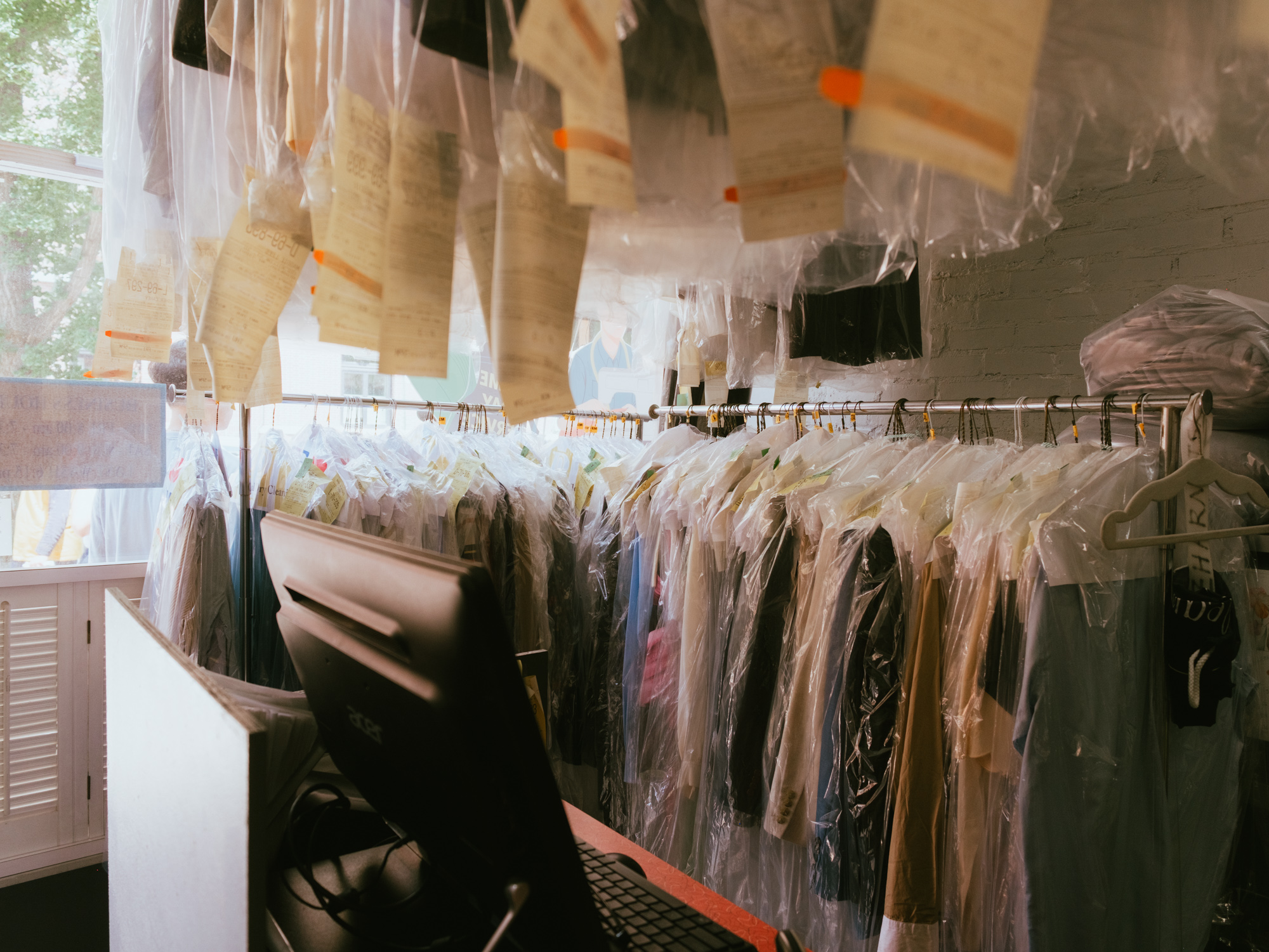 Freshly dry cleaned garments hanging in protective covers